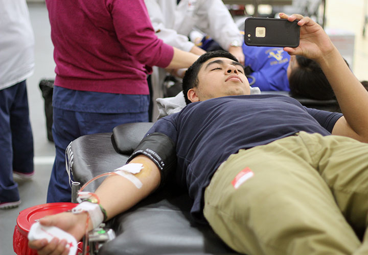  Bishop Amat senior Ricardo Rojas plays Clash of Clans while waiting to finish donating blood. 