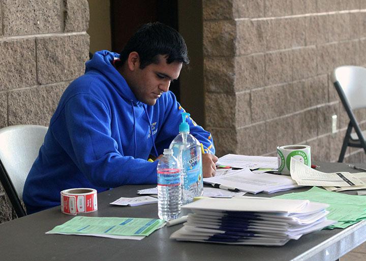 A Bishop Amat student checks in students at the front desk. 