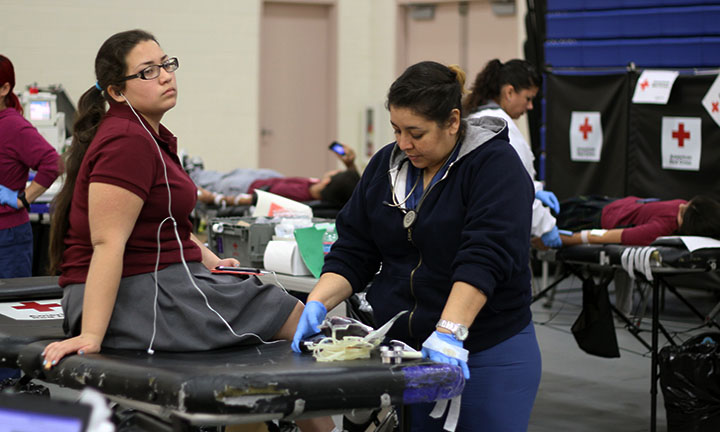 Bishop Amat student waits to get her blood drawn as the nurse verifies her identity once more.