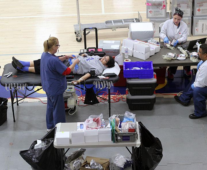 A Red Cross nurse prepares a Bishop Amat student to donate blood. 