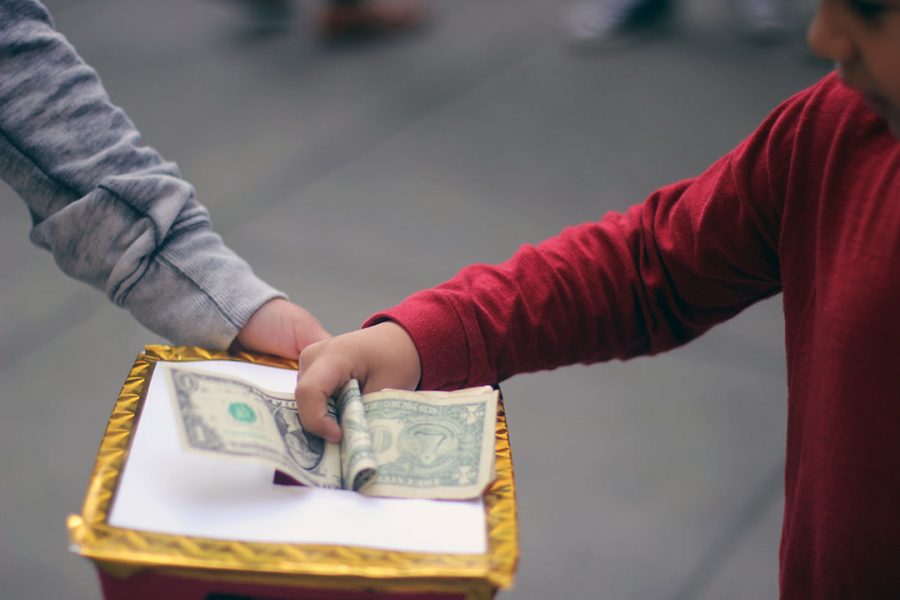 A student receives donations for various charities after Mass.