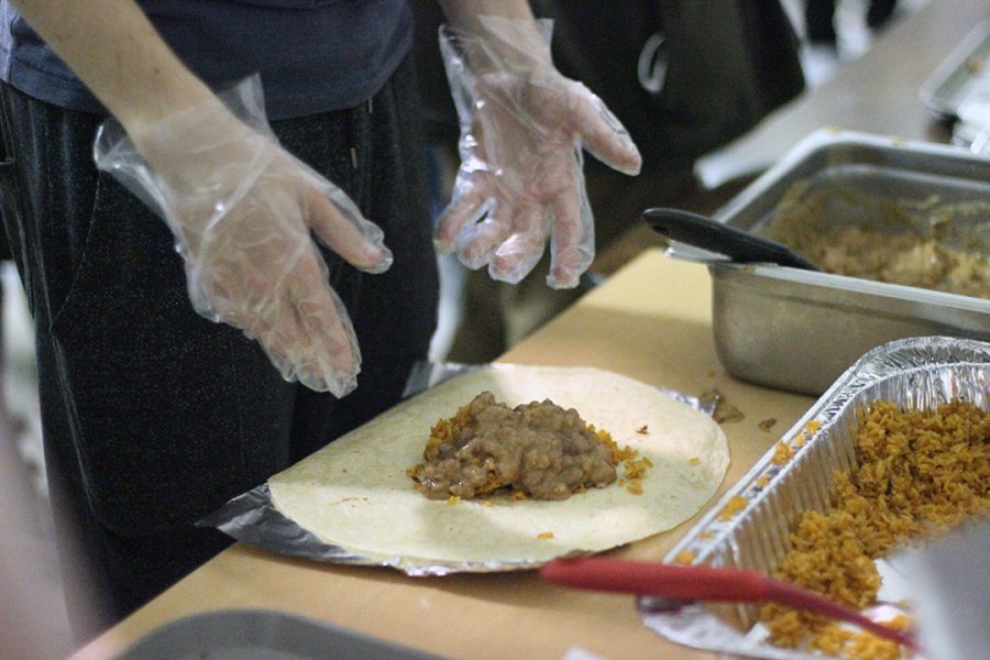 Hungry students make burritos with rice and beans for homeless on Skidrow.