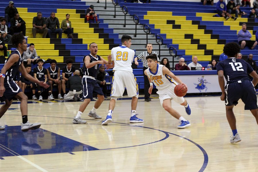 Vincent Rodriguez dribbles the ball while Jimmy Rodriguez blocks the defense. 