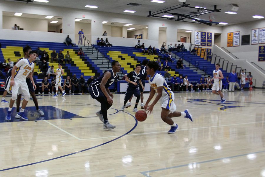 Damian Moore dribbles the ball up to the basket.