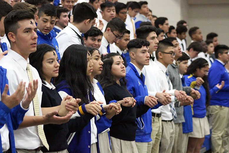 Students holding hands during prayer. 