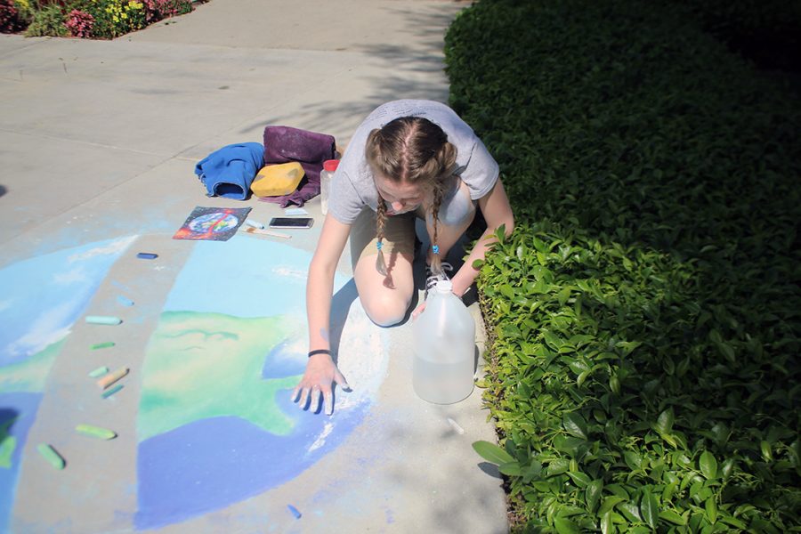 Senior Gillian Jones draws the planet Earth for her Chalk Walk submission.