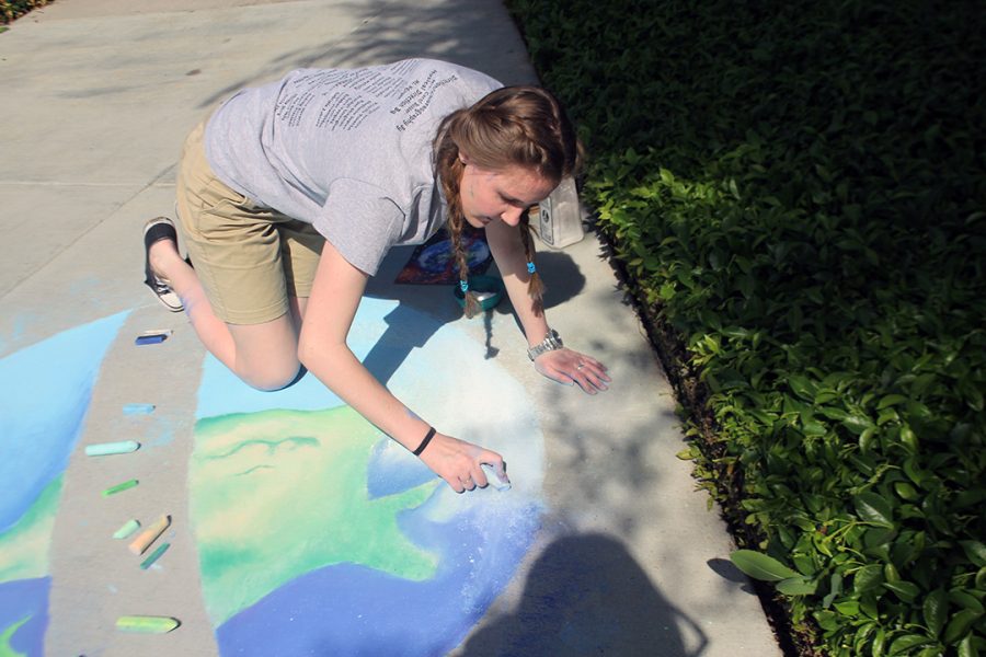 Senior Gillian Jones fills in the clouds to finish up her artwork. 