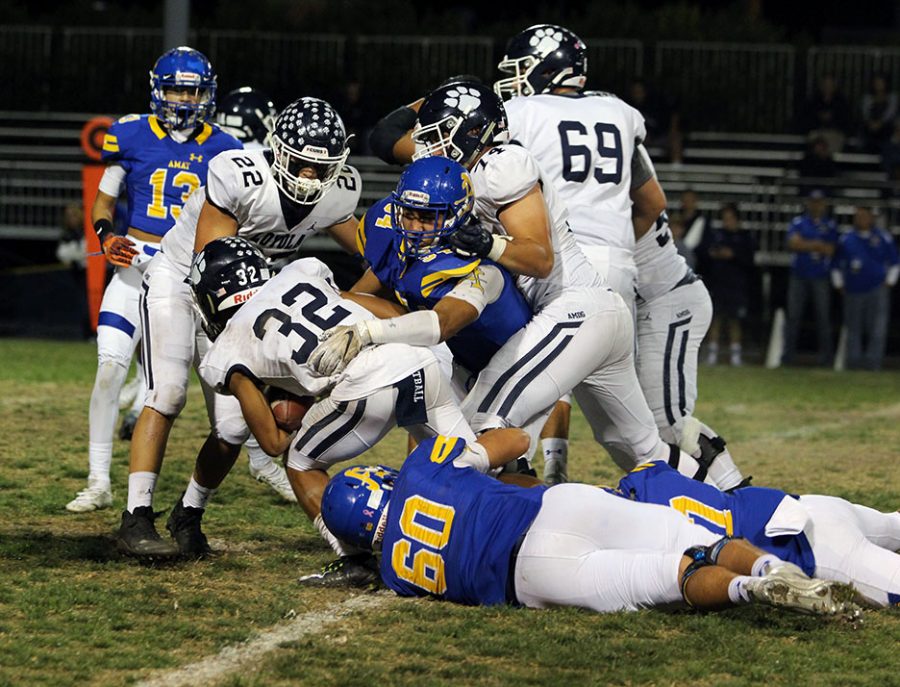 Senior Ethan Rodriguez (60) holds on tight to keep Loyola from scoring 