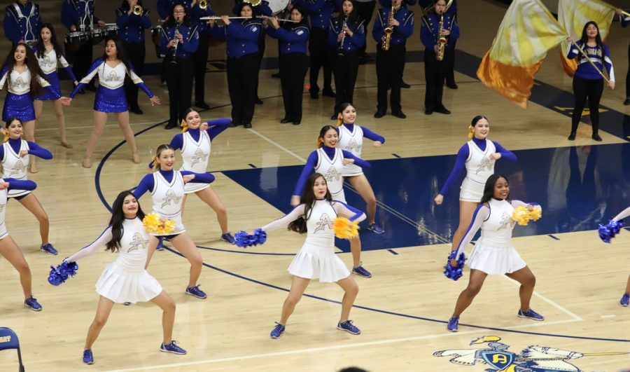 The cheer team is showing some dance moves. 