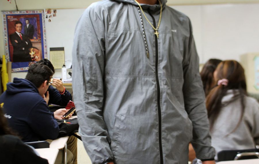 An unidentified student is wearing a light grey windbreaker. 