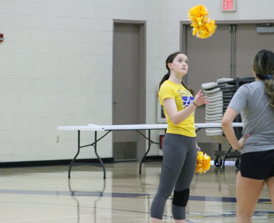 Hailey Gaul throws pom pom up in the air.