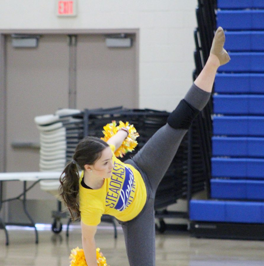 Hailey Gaul kicks leg high in the air during competition routine.
