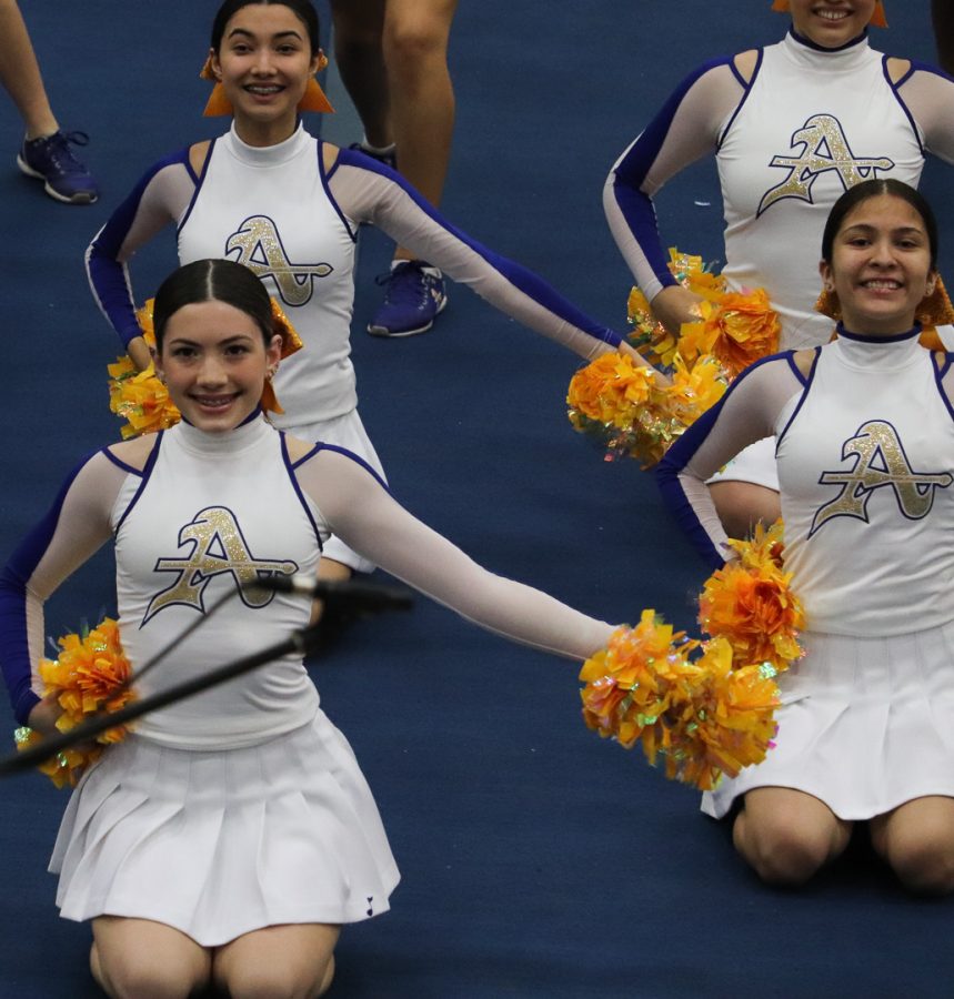 The cheer team is showing the visitors Amat's fight song. 