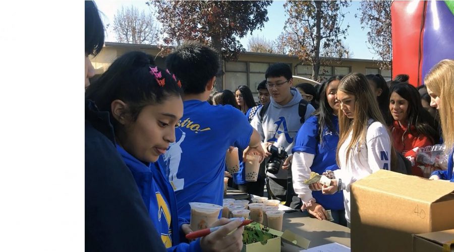 Interact Club officers selling the boba mile tea and mochi for the students who are waiting in a line.