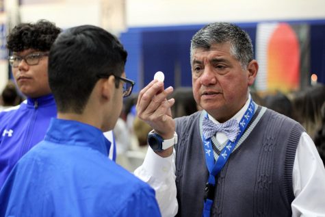 Mr. Canales  gives communion to a student.