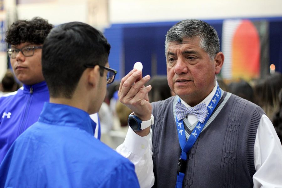 Mr.+Canales++gives+communion+to+a+student.