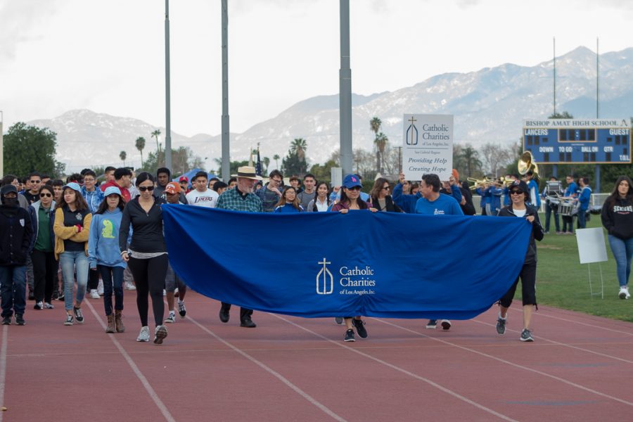 In+the+beginning+of+the+walk+volunteers+hold+up+the+banner+for+the+first+completed+lap.