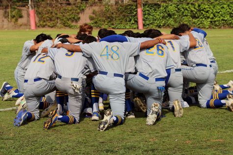 Team praying before taking the field. 