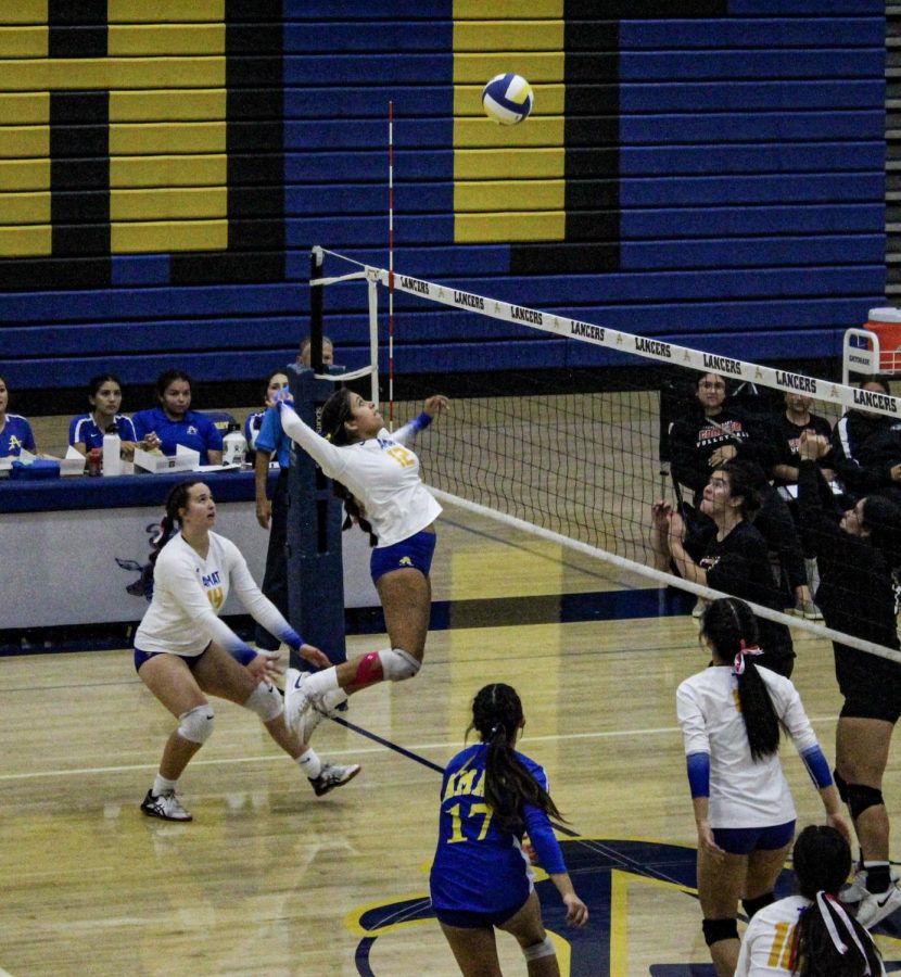 Mariyah Torres jumping to hit the ball. 