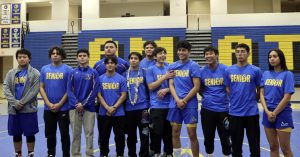 Amat Wrestling seniors gathering to pose for a picture on the mat
